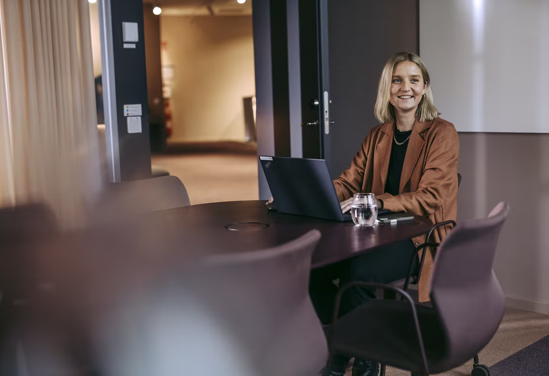 Forøyd dame som jobber på sin laptop